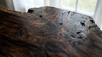 Weathered driftwood log with rich brown grain patterns and natural holes, rustic wooden texture for interior design and craft projects.