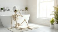 Skeleton relaxing in modern bathroom with Halloween self-care message, spooky humor concept for seasonal wellness and funny holiday decorating ideas.