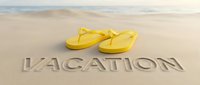 Yellow flip flops on sandy beach with vacation text carved in sand, ocean in background, summer holiday travel concept.