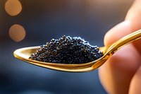 Black caviar on golden spoon held by hand against blurred bokeh background. Luxury gourmet food delicacy for fine dining and culinary presentations.