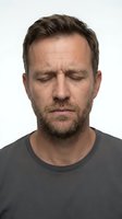 Caucasian middle-aged man with beard and closed eyes, expressing calm or sadness, isolated on white background, studio portrait.