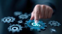 Digital automation concept with glowing blue gear mechanism and human finger touching virtual interface on dark background showing business process optimization.