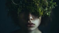 Mysterious portrait of person with face partially covered by lush green moss and plants, symbolizing connection between humanity and nature in environmental concept.