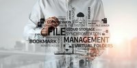 Professional businessman in white shirt pointing at digital file management word cloud with technology terms for modern office workflow and data organization.