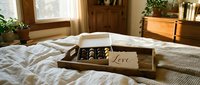 Wooden tray with chocolate box and love note on cozy bed in warm bedroom, romantic Valentine's Day morning surprise concept.