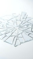 Shattered glass fragments radiating from center point on white background, depicting breakage, damage, and destruction for design projects.