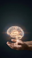 Glowing brain hologram floating above open hands representing artificial intelligence, mental health, neuroscience and cognitive psychology concepts.