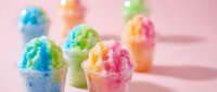 Colorful shaved ice cups with vibrant blue, green, pink, and yellow flavors arranged on pink background. Isolated design element for summer beverages, dessert menus, and food service marketing.