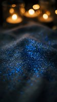Blue glitter sparkles with warm bokeh lights creating magical atmosphere for luxury cosmetics and celebration backgrounds.