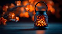 Decorative lantern with glowing orange light against dark background with blurred autumn leaves creating cozy atmospheric mood for seasonal design.