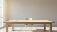 Minimalist wooden dining table with single bowl in bright modern interior with large windows and natural sunlight streaming across neutral walls.