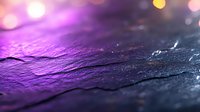 Dramatic purple and blue textured stone surface with bokeh light effects in background creates mystical atmospheric mood for abstract backgrounds.