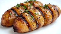 Grilled sliced potatoes with herbs and seasoning on white background, roasted vegetable side dish for cooking and recipe content.