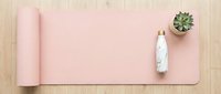Pink yoga mat with water bottle and succulent plant on wooden floor, flat lay overhead view for fitness and wellness design projects.