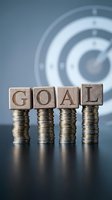 Wooden blocks spelling GOAL on stacked coins with target background representing financial planning and business success achievement strategy.