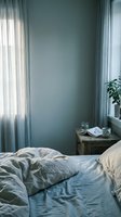Cozy bedroom interior with unmade bed, soft natural light filtering through sheer curtains, wooden nightstand with coffee cup and book creating peaceful morning atmosphere.