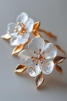 Elegant white crystal flower brooch with rose gold leaves and diamond centers on soft gray background, luxury jewelry accessory for special occasions.