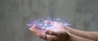 Hands holding glowing holographic data visualization with wave patterns and digital graphs, representing technology, analytics, and future innovation concepts.