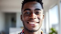 Young African American man with bright smile and positive expression in modern home interior for lifestyle and wellness content.