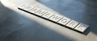 Wooden letter blocks spelling TEAMWORK on concrete surface with dramatic lighting and shadows for business collaboration concepts.