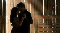 Romantic couple embracing in rustic barn with warm sunlight streaming through wooden slats creating intimate atmosphere for wedding photography and love stories.