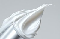White cream swirl with smooth flowing texture on gray background for skincare and cosmetic product advertising.