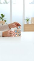 Hands arranging wooden blocks with environmental icons on white desk in bright modern office with plants for eco-friendly business concept.