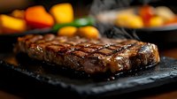 Juicy grilled beef steak with grill marks on black stone plate, steaming hot with vegetables in background. Perfect for restaurant menu promotion.