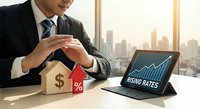 Professional businessman analyzing rising mortgage rates on tablet with wooden house model and percentage symbol in modern office overlooking city skyline.