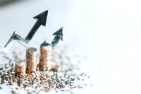 Stacks of gold coins with rising arrows showing financial growth and success, scattered glitter on white background creates luxurious investment concept.