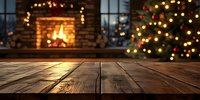 Rustic wooden table with blurred Christmas tree and cozy fireplace in background creating festive holiday atmosphere.