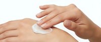 Young adult female hands applying white moisturizing cream or lotion to arm skin against white background, suitable for skincare, cosmetics, and beauty product marketing.