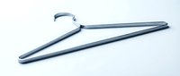 Minimalist silver metal clothes hanger lying flat on a light background, showcasing sleek design for fashion, retail, and laundry concepts.