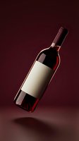 Red wine bottle with blank white label floating on burgundy background for branding mockup and product presentation.