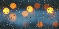 Blurred city lights through wet window glass with raindrops at dusk. Bokeh circles create dreamy atmosphere against dark blue evening sky background.