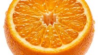 Fresh orange slice cut in half showing juicy citrus segments and pulp, isolated on white background for food and beverage design use.