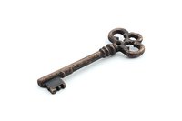 Antique ornate skeleton key with rustic copper patina finish isolated on white background, featuring decorative baroque style bow and ornamental bits for vintage decor.
