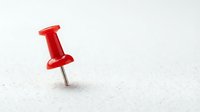 Red pushpin thumbtack isolated on white background for office supplies, bulletin board organization, and graphic design projects.