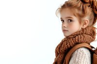 Young girl with ginger hair wearing knitted brown scarf and cream sweater looking away thoughtfully against white background, fashion portrait in warm autumn colors.