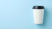 White paper coffee cup with black lid on light blue background, copy space for branding and mockup design use.