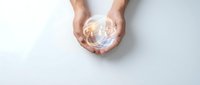Hands holding glowing globe with light energy, representing global connection, sustainability, and environmental care for business and technology concepts.