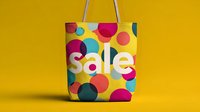 Colorful shopping bag with sale text on bright yellow background, featuring vibrant pink, blue, and teal polka dot pattern for retail promotion.