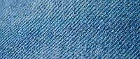 Blue denim fabric texture with diagonal weave pattern showing cotton fibers and textile details for fashion and clothing design projects.