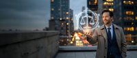 Professional Asian male lawyer holding glowing justice scales hologram on city rooftop at dusk with illuminated skyscrapers background for legal technology concepts.