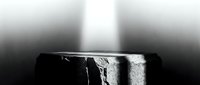 Ancient stone pedestal with dramatic light beam from above in dark moody atmosphere, perfect for product display or luxury presentation.