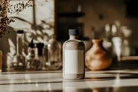 Minimalist brown glass bottle with blank label on wooden surface, soft natural lighting creates gentle shadows, pottery vase in blurred background.
