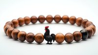 Stylish wooden bead bracelet with black rooster charm on white background, fashion accessory for spiritual protection and good luck.