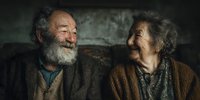 Happy elderly couple laughing together in warm lighting showing genuine joy and connection in their golden years of marriage and companionship.