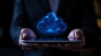 Glowing blue holographic cloud floating above smartphone held by business person in dark environment, representing digital transformation and cloud computing.