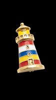 Decorative lighthouse with brass accents and colorful striped bands in red, white, blue, and yellow. Isolated on transparent background, ready for clipart, t-shirt design, stickers, and print-on-demand products.
